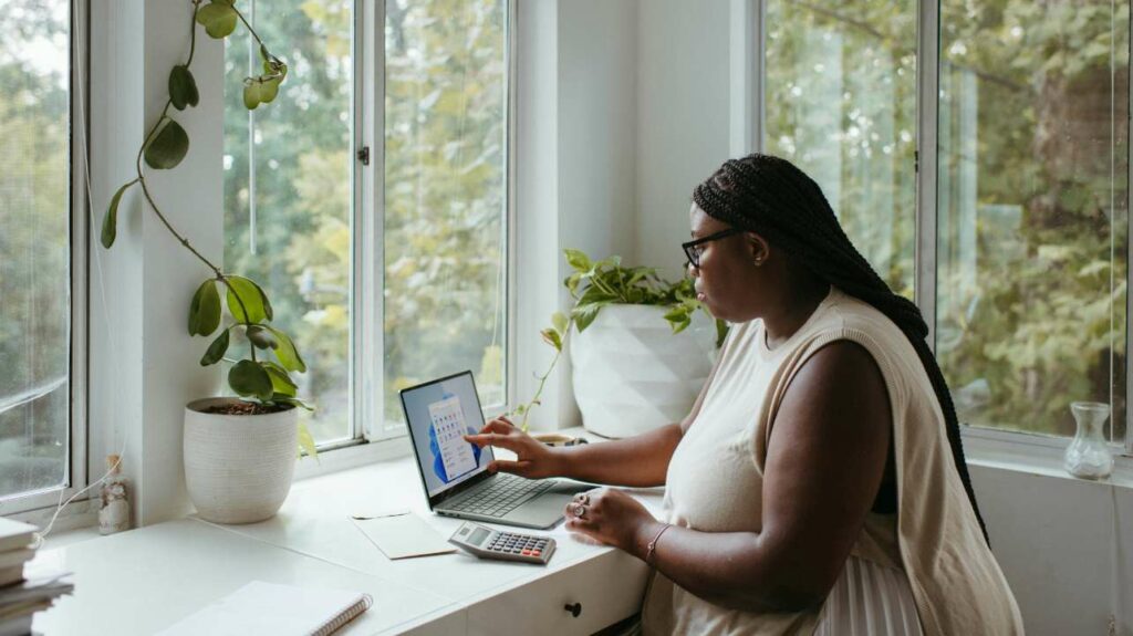 Woman working from home on laptop while looking out window